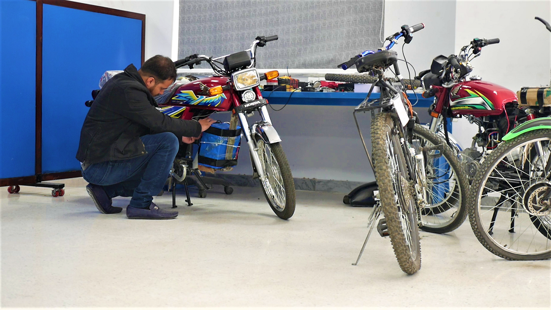 Researcher at the University of Lahore converting petrol motorcycle to an electric bike
